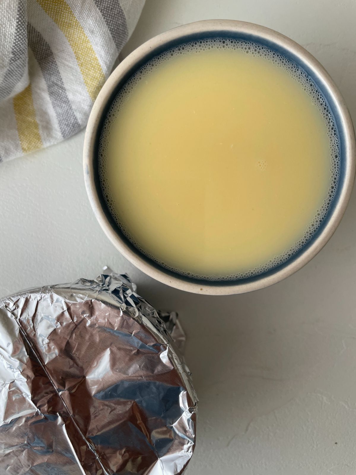 Egg mixture in ramekin covered in foil
