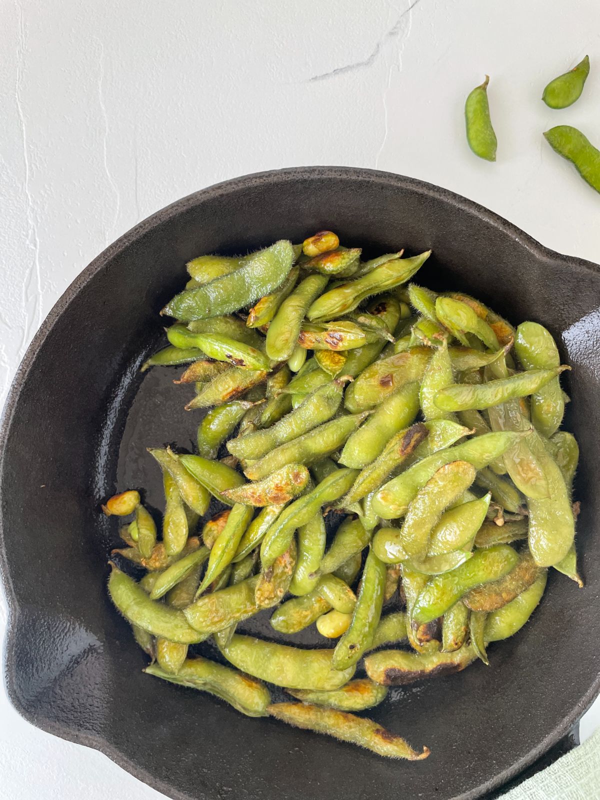 edamame being pan fried in a skillet