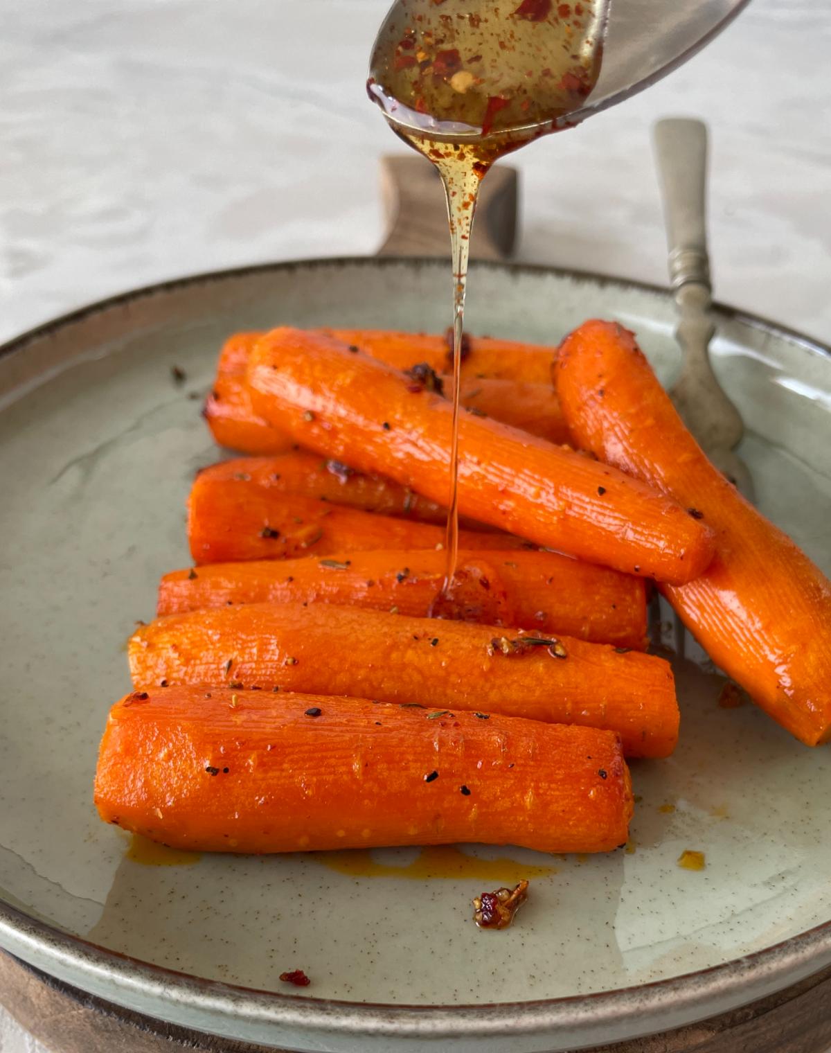 drizzling hot honey over hot honey carrots