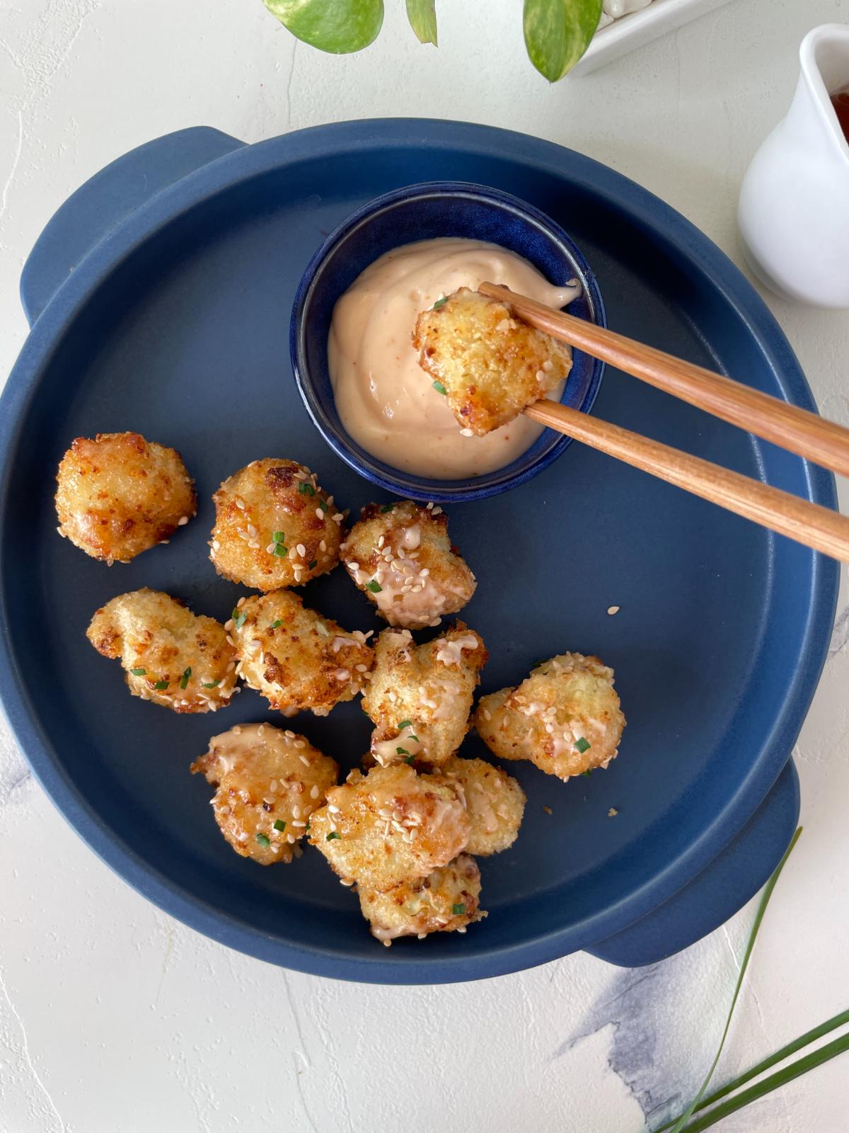 air fryer bang bang cauliflower served in a plate with a dipping sauce