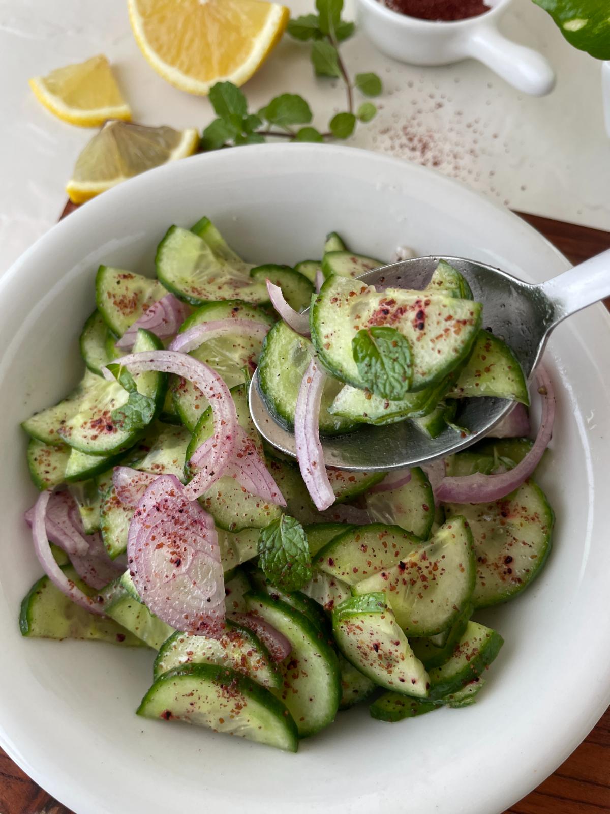 sumac cucumber salad being served in  a bowl