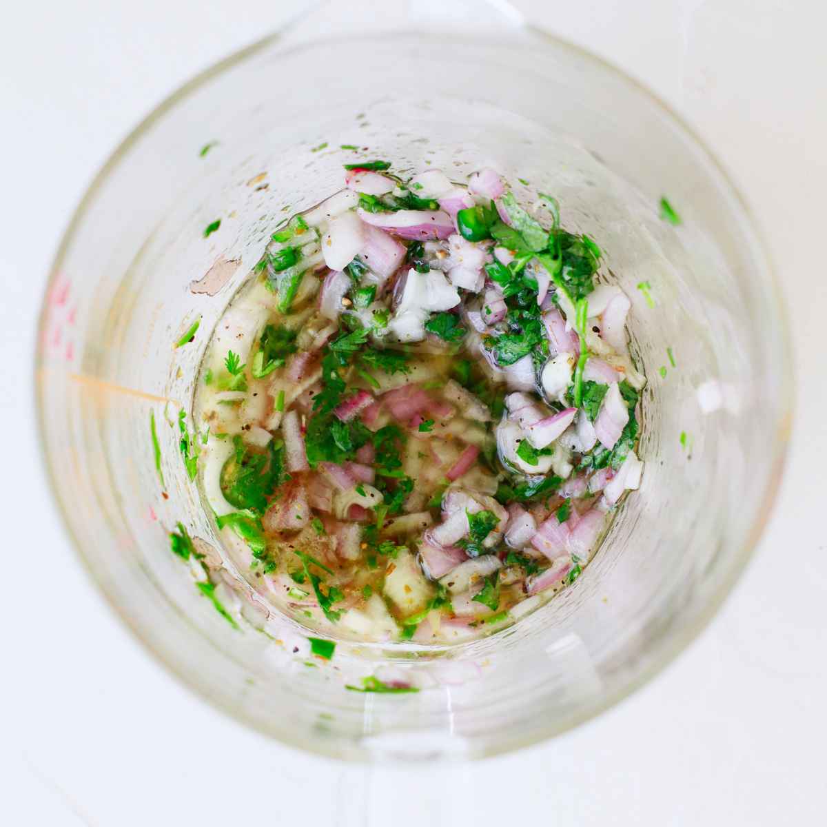 Combine chopped onion and garlic with the lime juice, apple cider vinegar, oil, cilantro and seasonings in another bowl