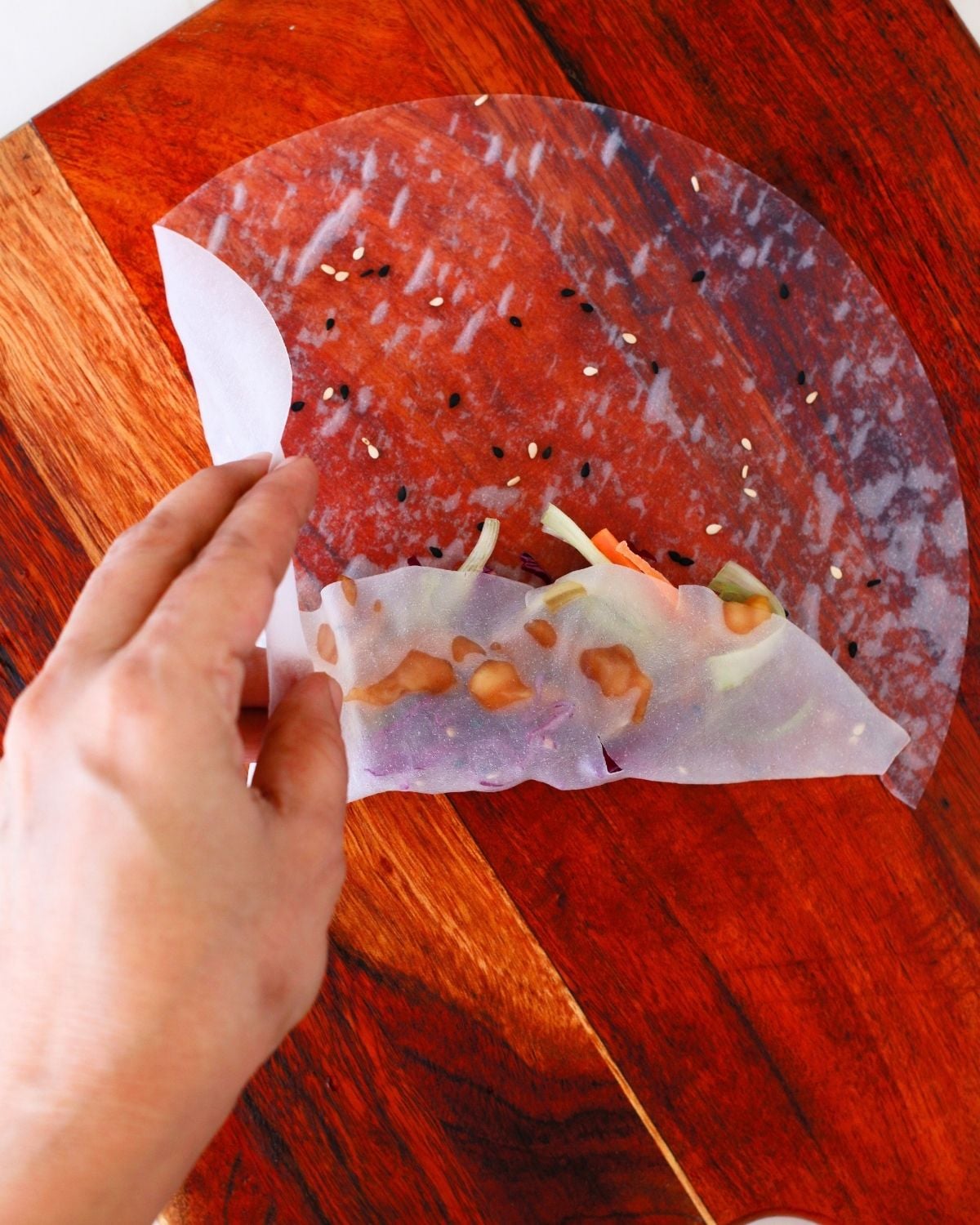 Bottom and side of rice paper folded over the filling