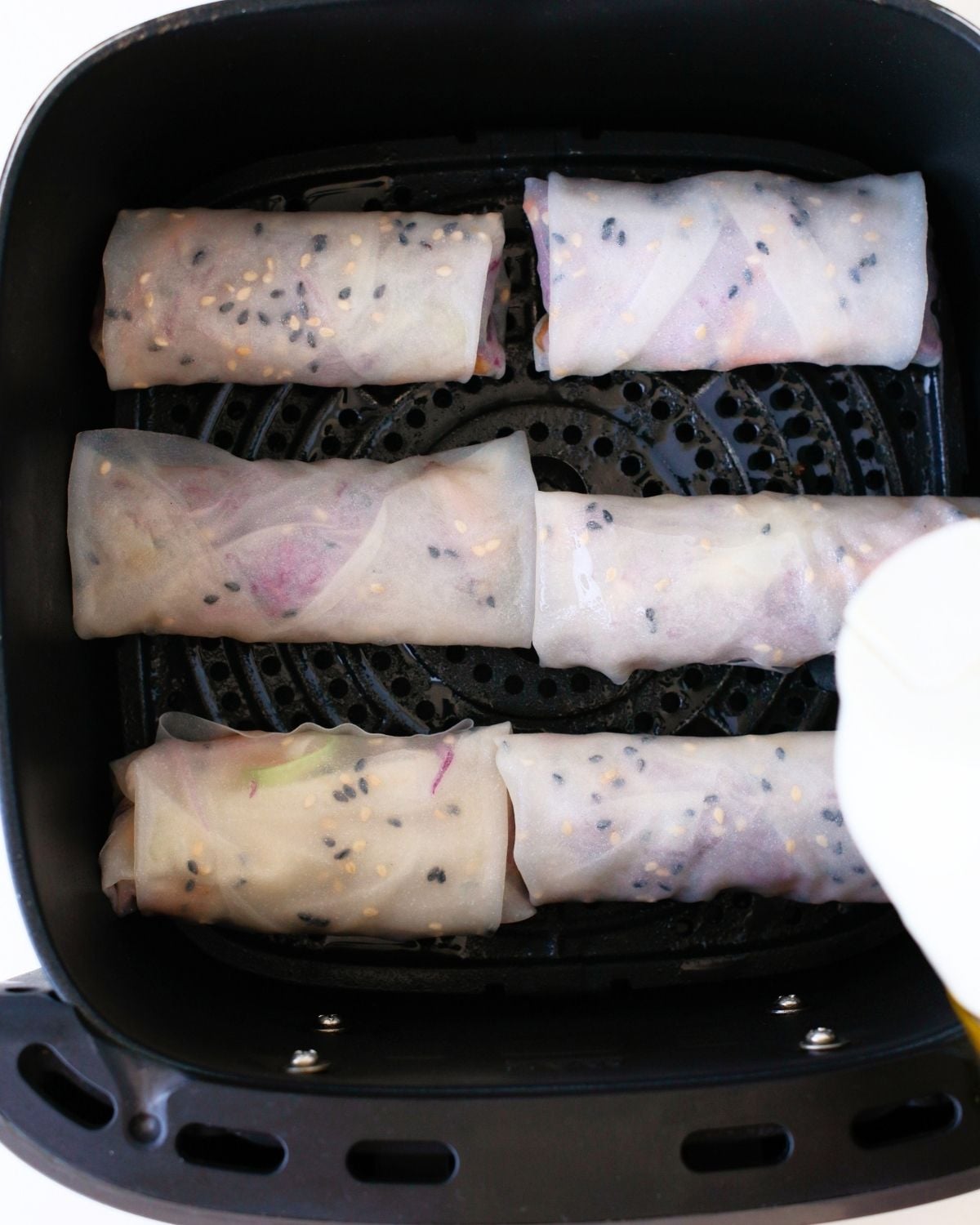 Chicken rice paper dumplings arranged in an air fryer basket