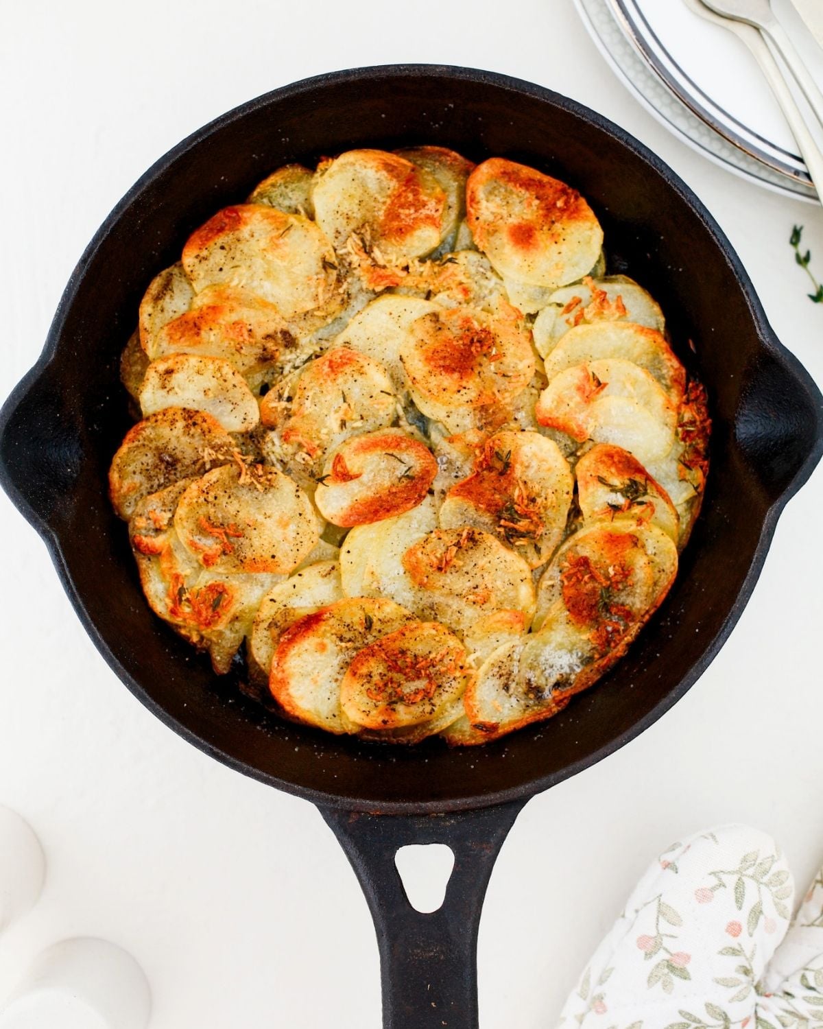 Golden baked Anna potatoes in a skillet