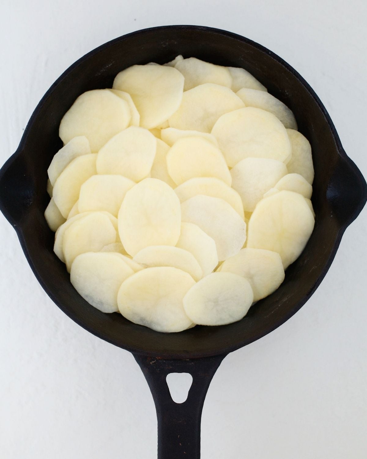 Overlapping potato slices in a skillet