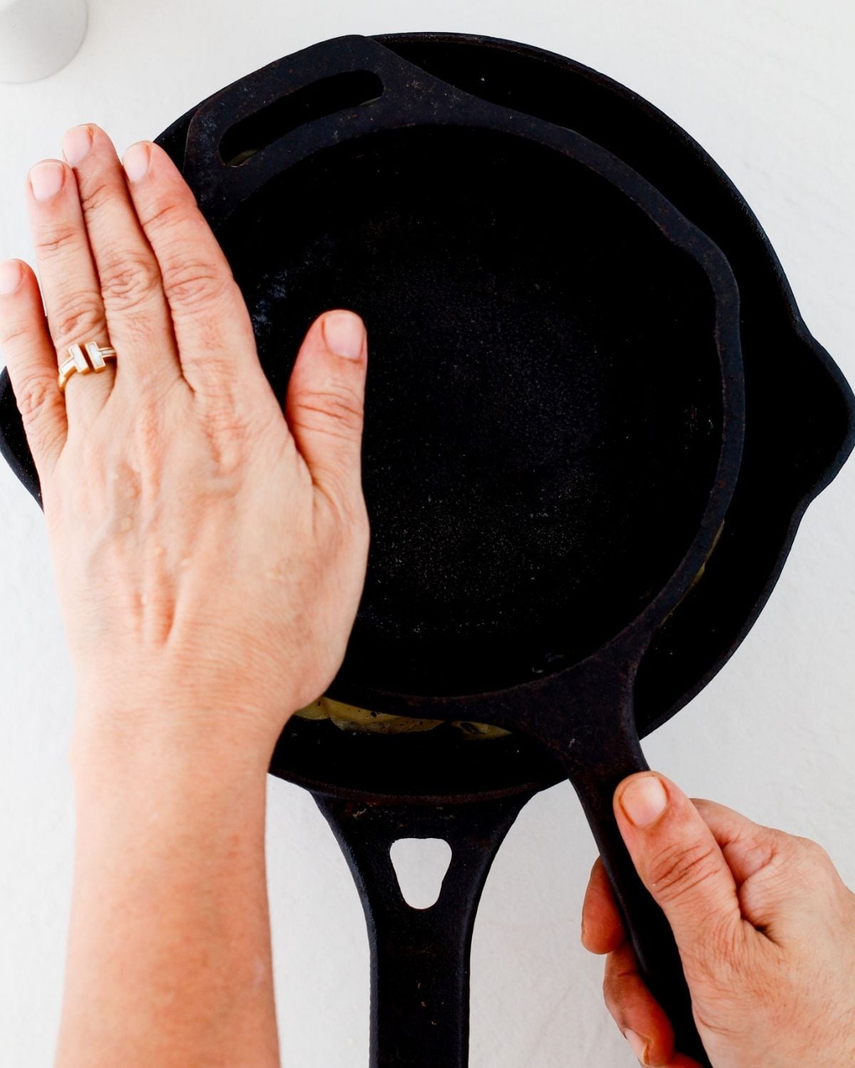 A second skillet weighing down the potato layers