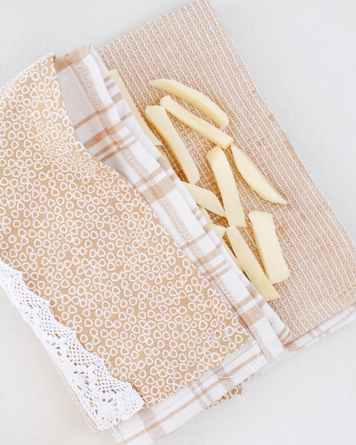 Cut potato fries drying on a kitchen towel