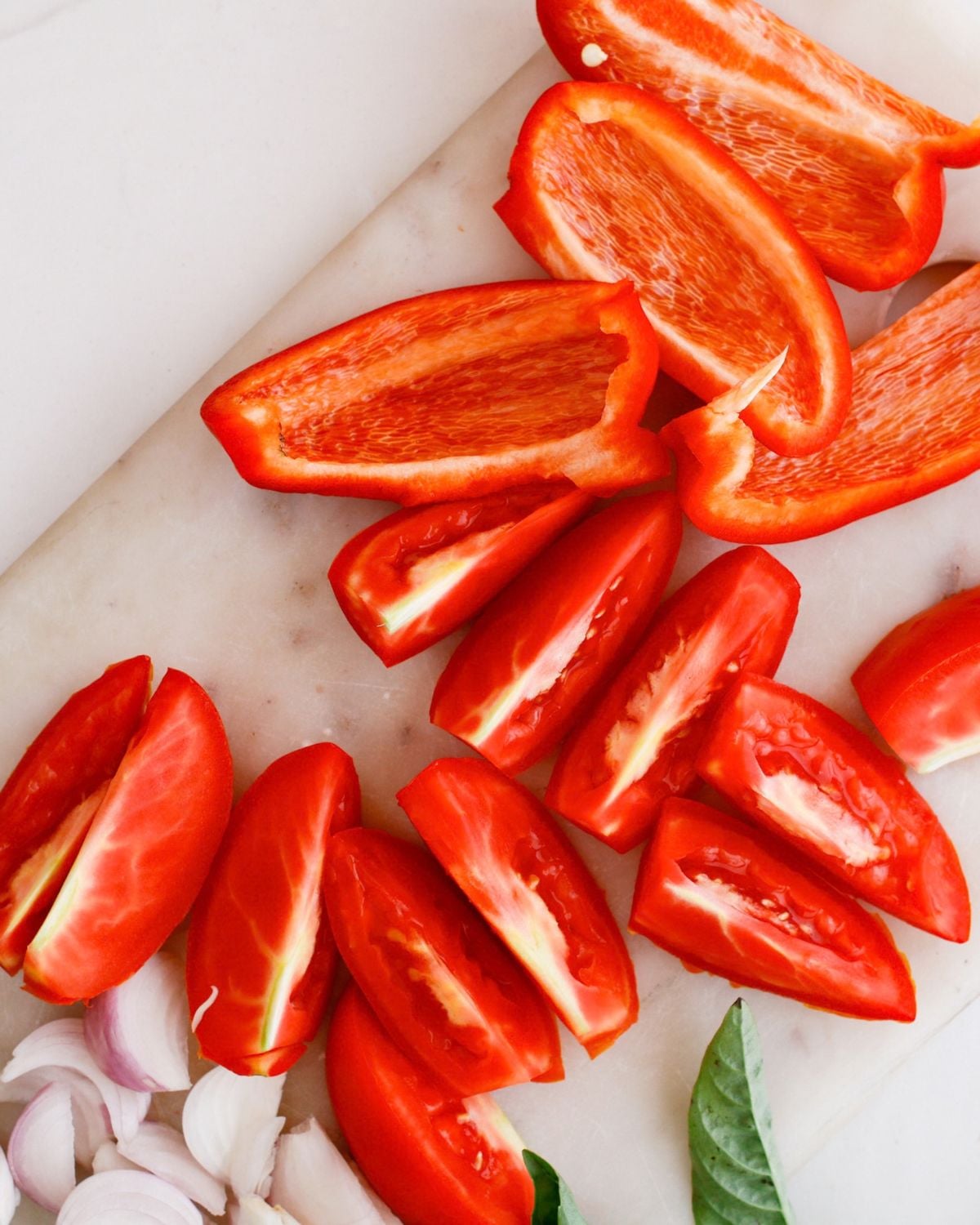 Chopped tomatoes and red bell pepper ready for roasting